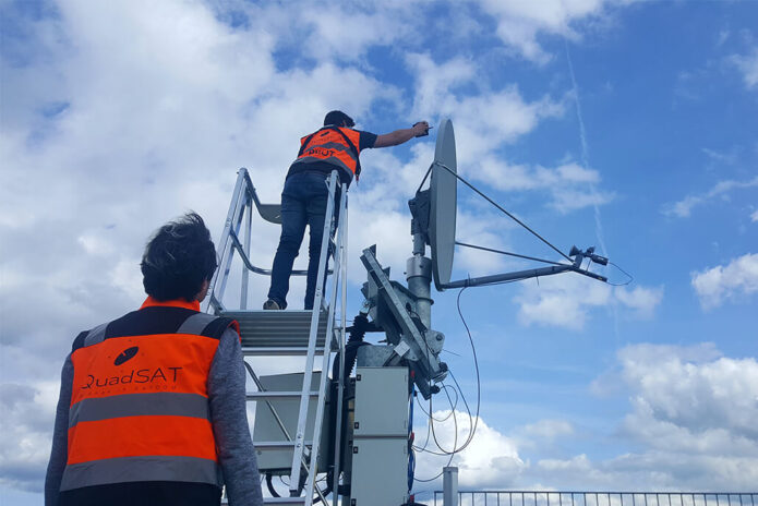Quadsat technicians taking measurement from antenna with new technology